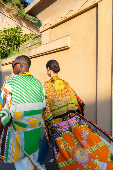 2 mannequins de dos qui porte des tuniques en upcycling venant de la marque 2 mai paris . Les motifs sont hyper variés: le mannequin de gauche a des motifs rectangulaires et en rayures vert et jaune. Celui de droit a à des motifs orange, noir et jaune beaucoup plus disperse.