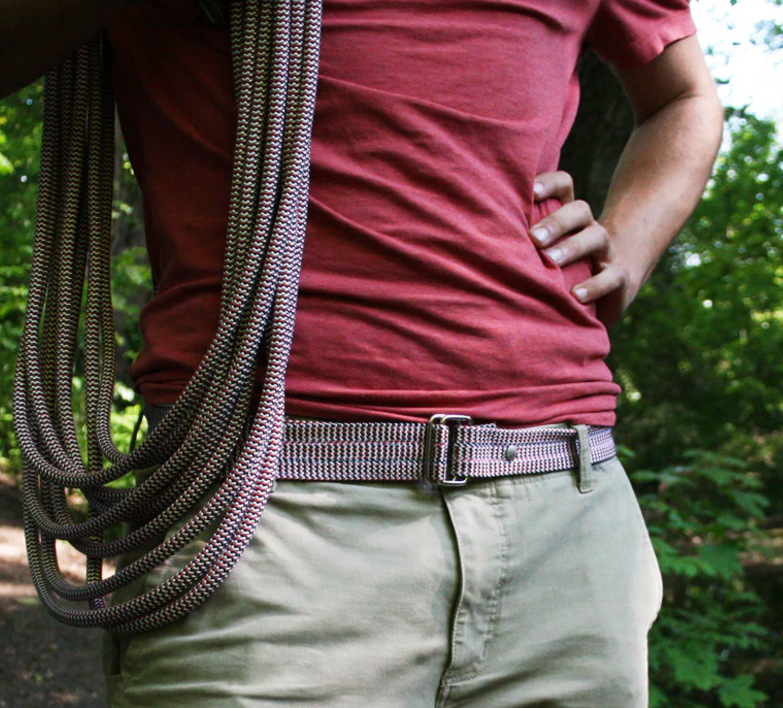 plan proche des hanches d'un mannequin qui porte une ceinture de la marque la vie est belt. il porte des cordes sur son epaule car la ceinture est faite en corde d'upcycling.