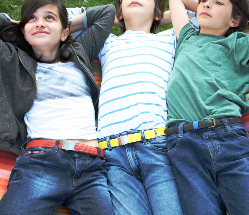 3 enfants mannequin qui portent des ceintures de la marque la vie est belt. les ceintures sont rouge, jaune et noir.