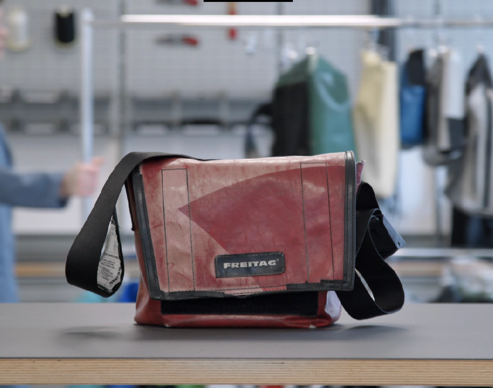 Sac freitag rouge avec le logo noir et la sangle noire