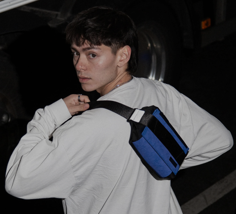 mannequin homme de dos avec une banane freitag bleue autour du dos avec une sangle noire