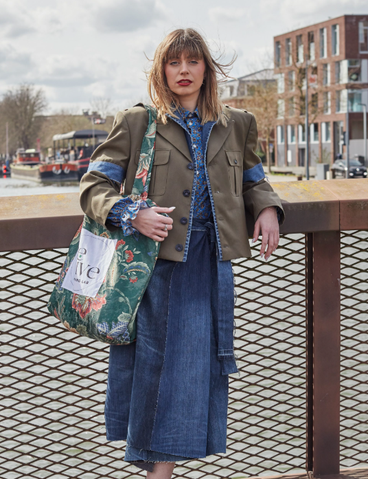Mannequin portant 2 peice de revive lab . une veste kaki avec des epaule s déconstruit et des ajouts en jean sur les manches. avec un ensemble en jean en dessous cette veste