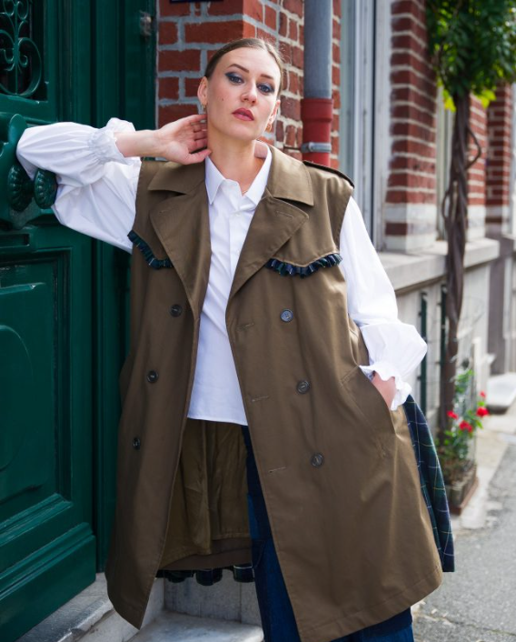 mannequin qui porte un trench coat vert kaki d'upcycling sans manche et avec des bordures en jean. Venant de la marque Revive Lab