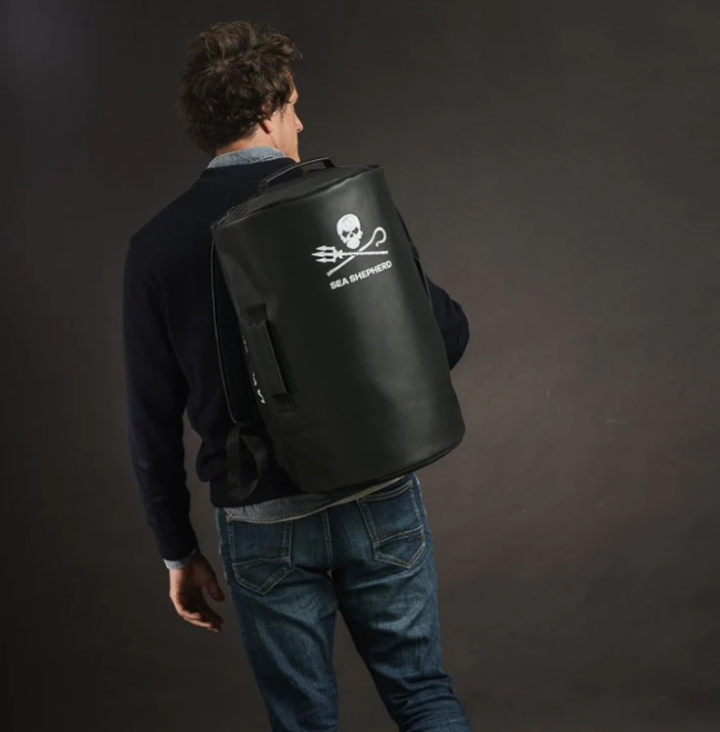 un mannequin qui porte un sac noir avec un logo